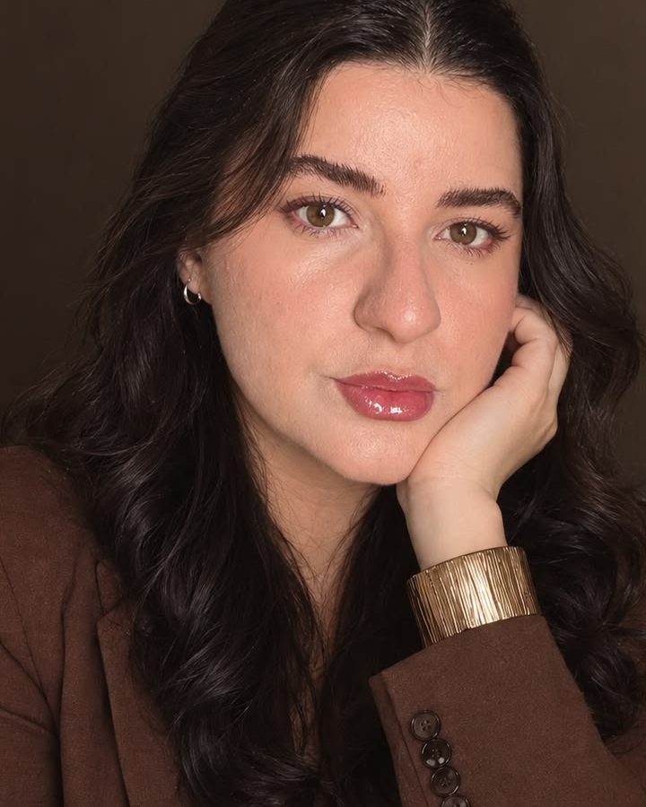 Retrato de Mari Silva com a mão apoiada no rosto e bracelete dourado